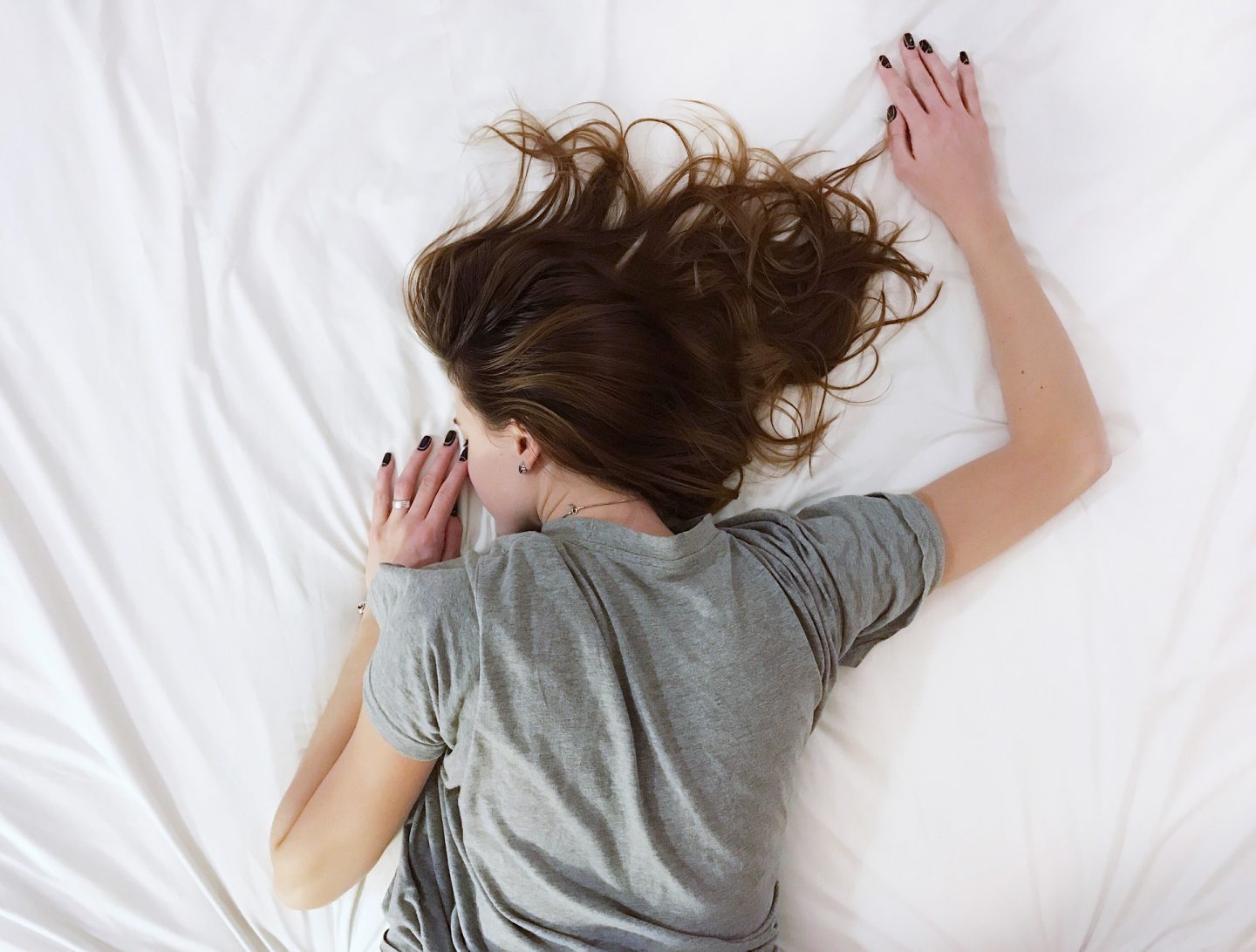 a woman lying face down on a white bed