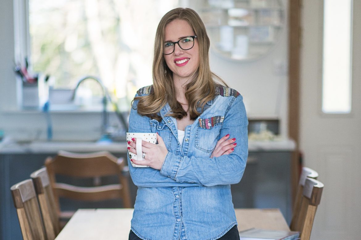 Virtual Assistant | Woman sitting on the kitchen table wearing black jeans and a denim shirt