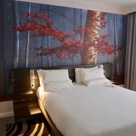 A hotel bed in a Novotel Hotel room