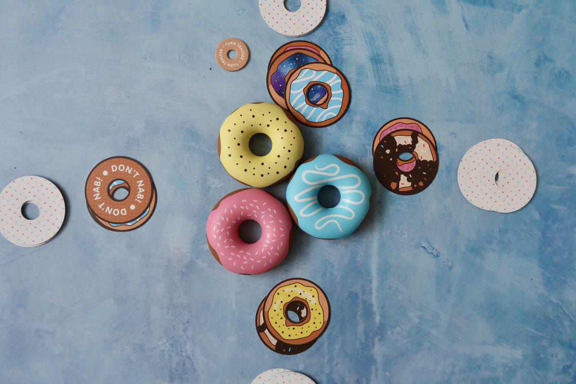 Plastic donuts and donut cards laid out as park of the Dough Nab game