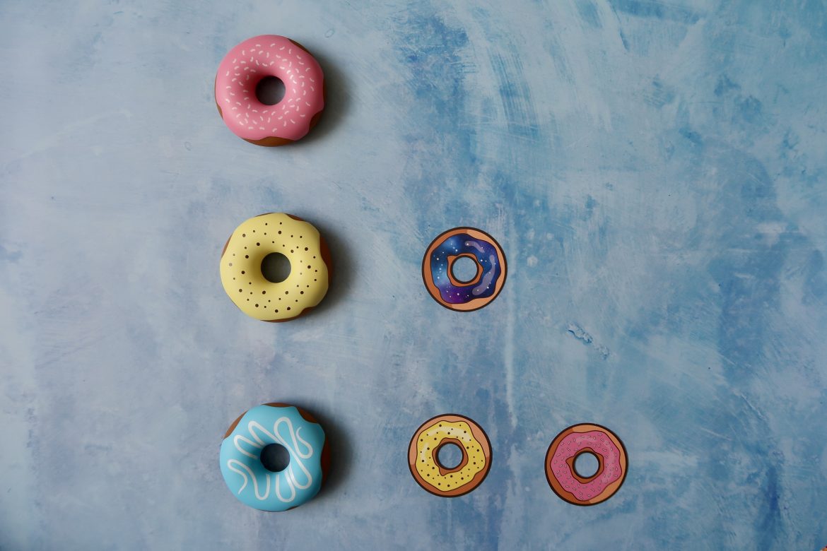 3 plastic donuts and 3 card donuts are stacked to make a triangle