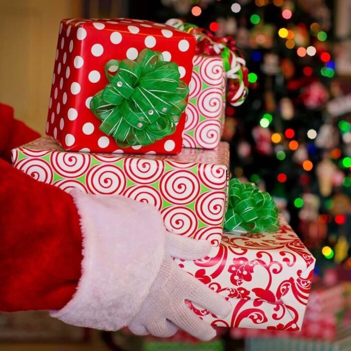 The hands of Santa holding a stack of presents