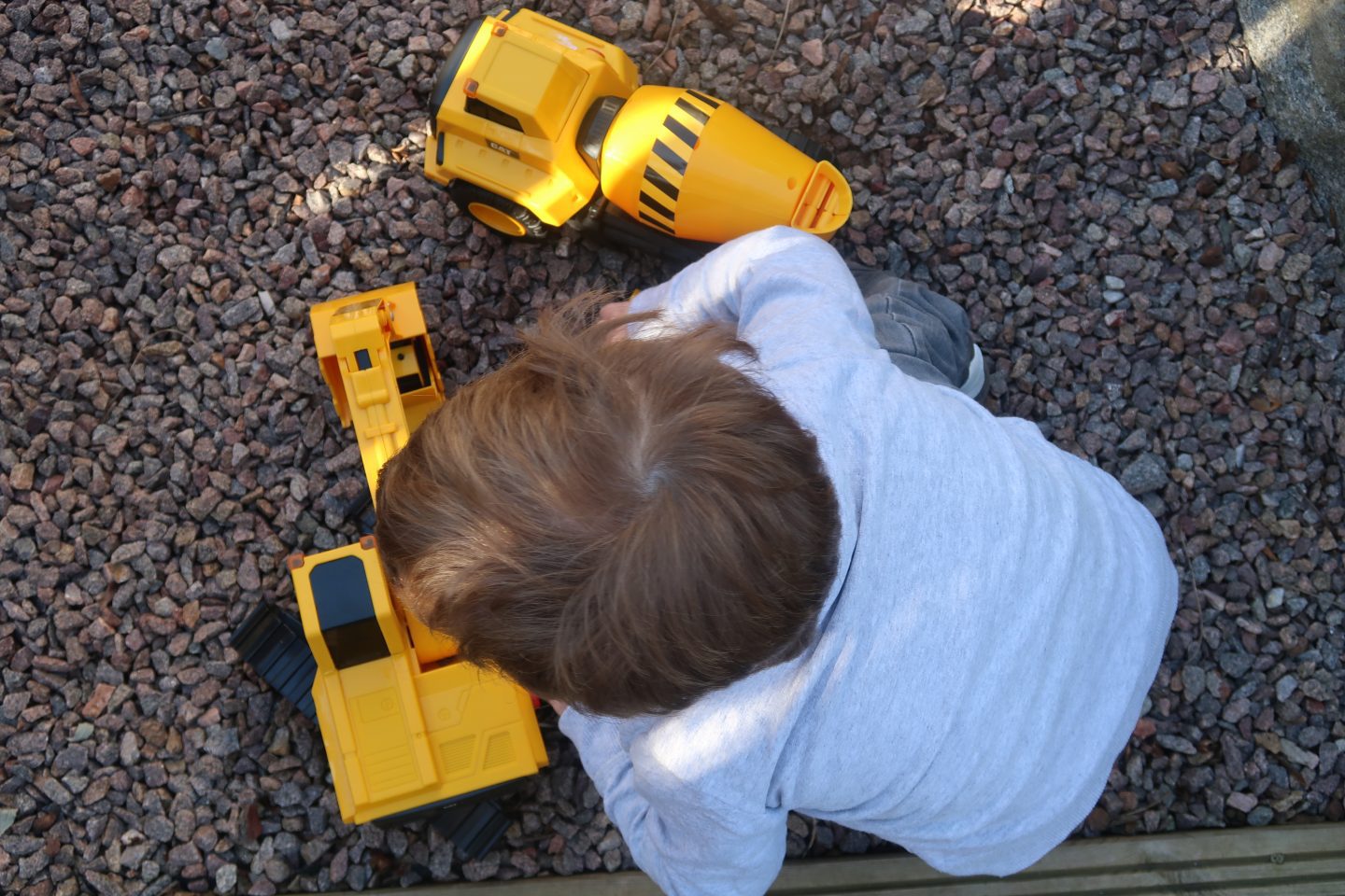 A top down view of a child playing with Cat toys Power Haulers