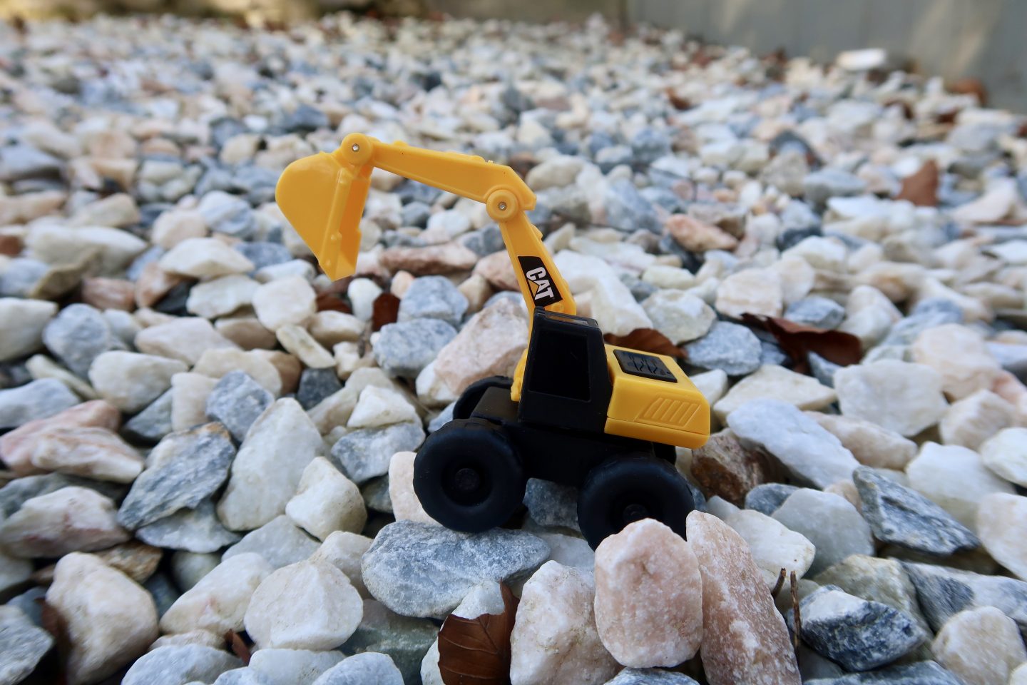 A small Cat toy digger on stones