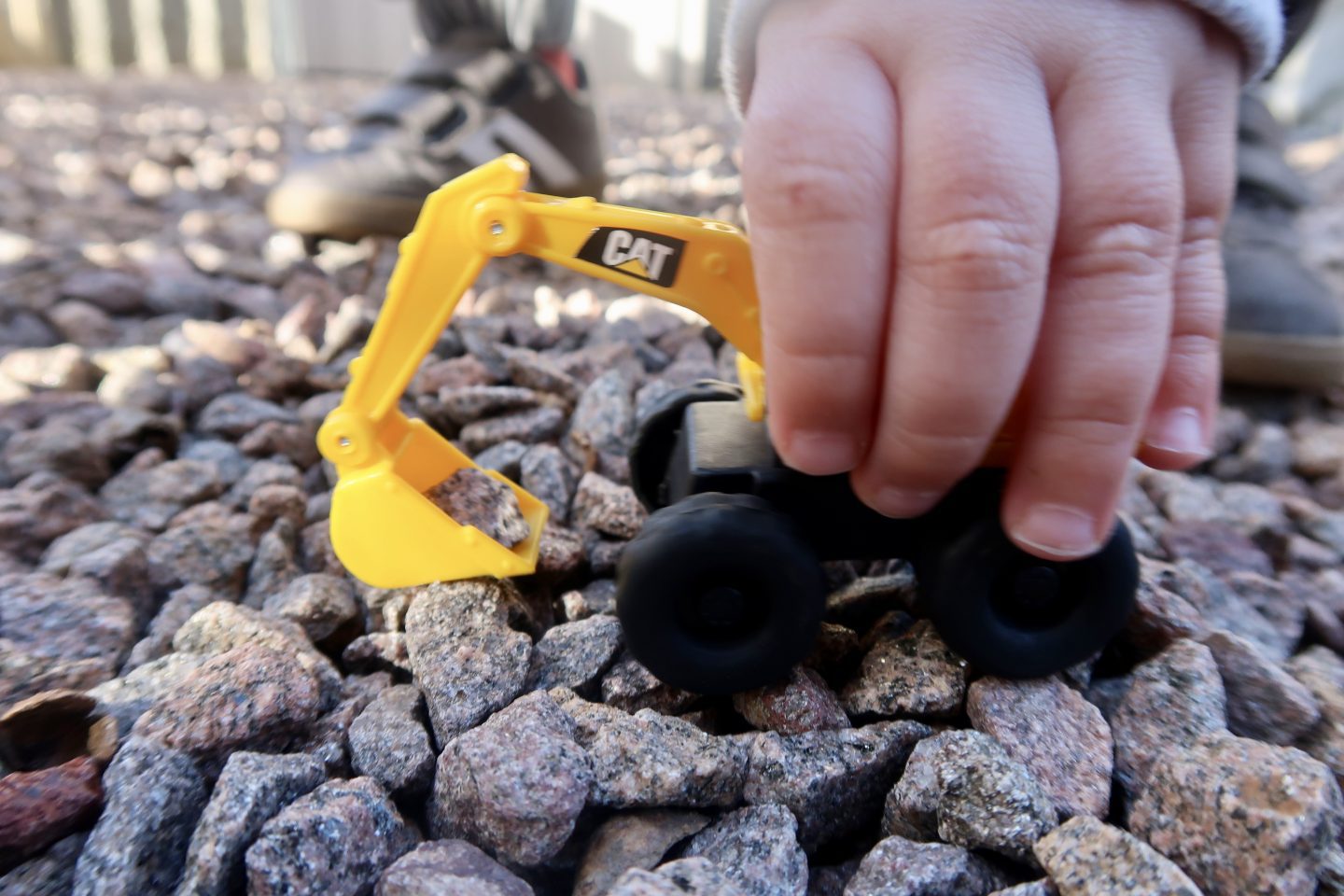 A childs hand holding a toy digger