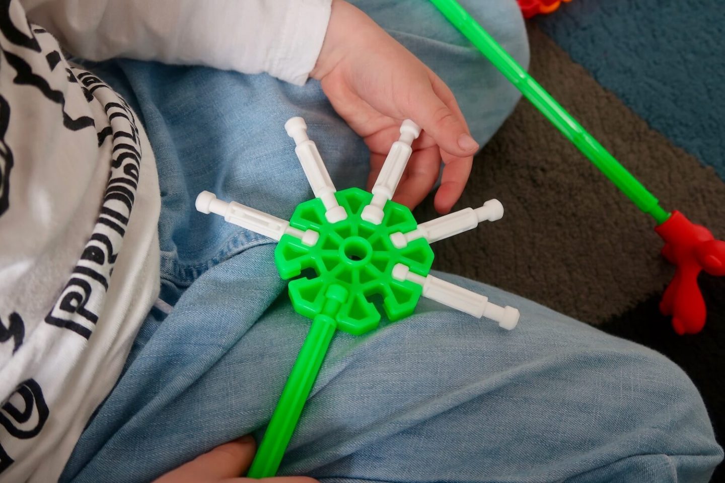 A green K'Nex disc with white rods in it