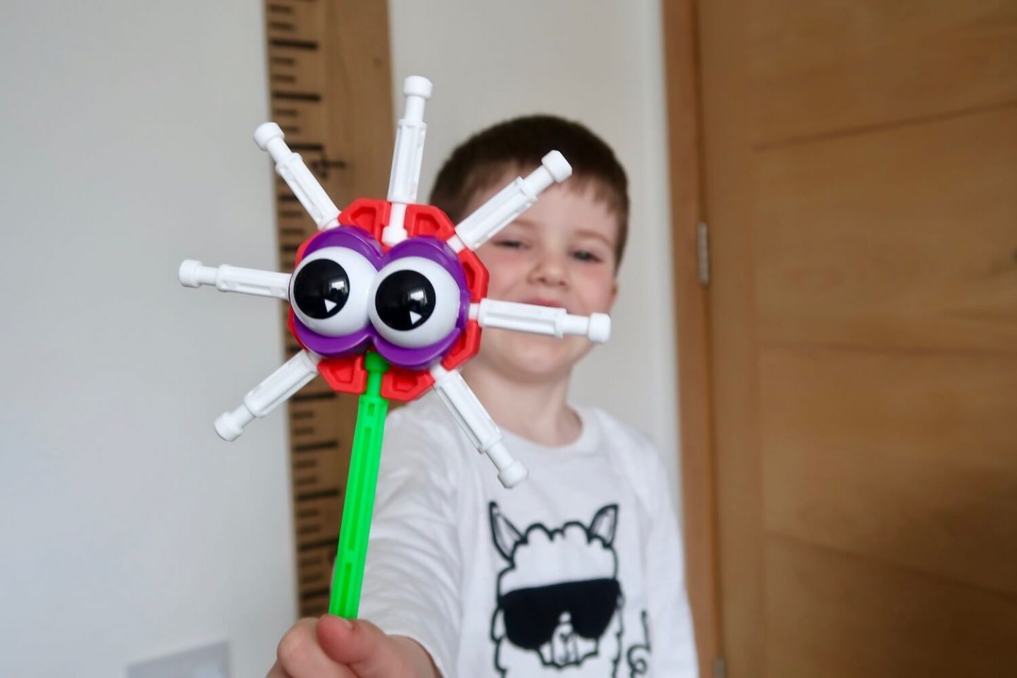 A child holding out a K'Nex monster