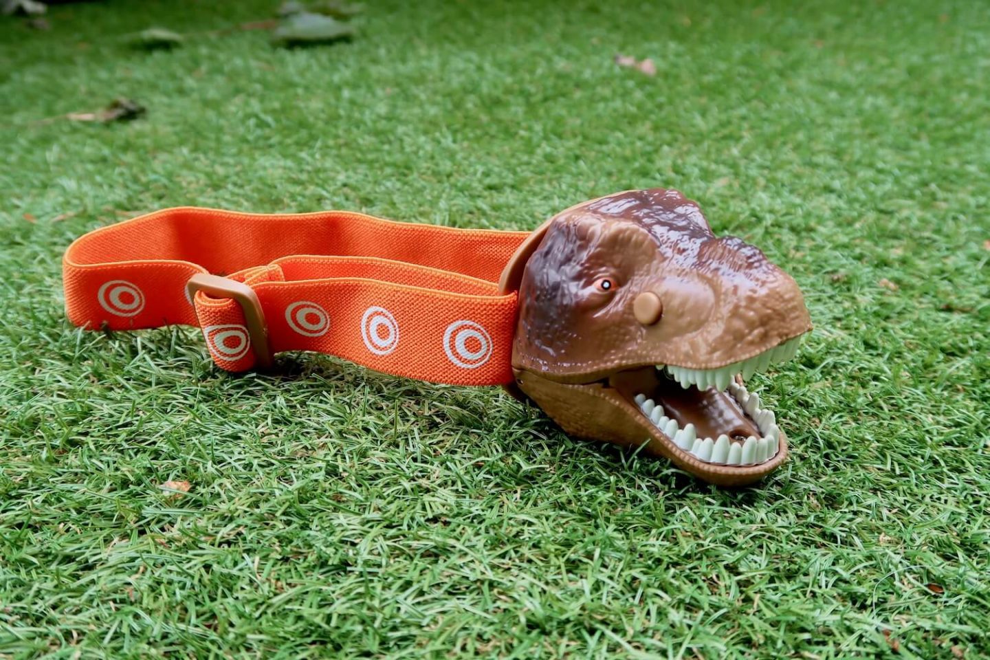 A T-Rex Dinosaur head torch on grass