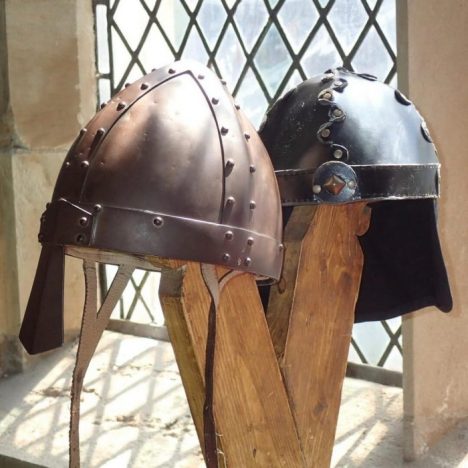 two viking hats on posts in front of a window
