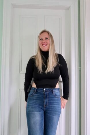 A woman wearing a black bodysuit and jeans