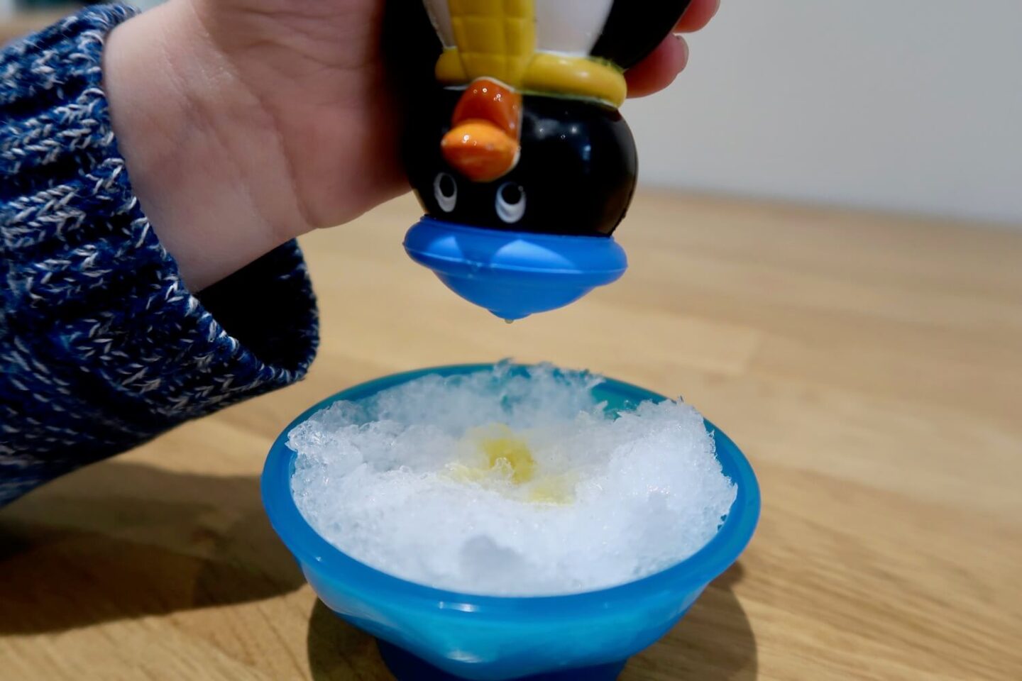A bowl of crushed ice, with someone pouring