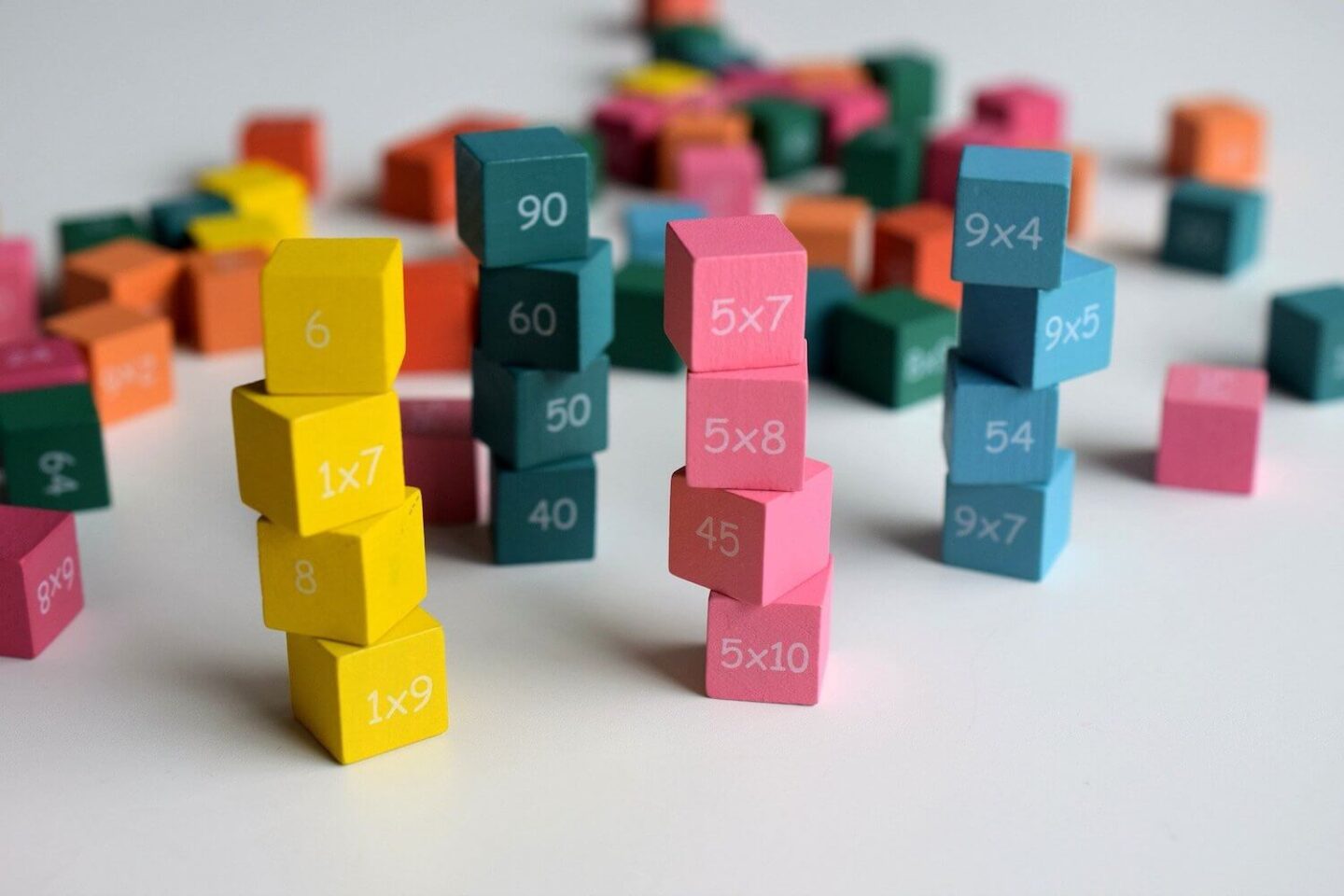 coloured blocks stacked according to their colour. Each block has a maths sum or a number on them.