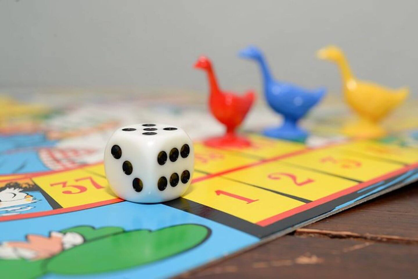 A board game with a dice and bird characters