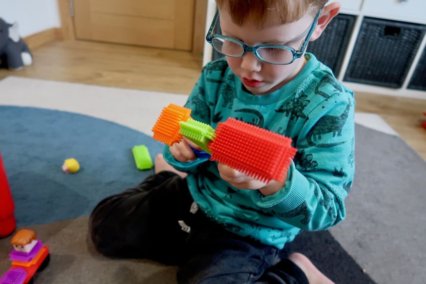 A boy playing with stickle bricks