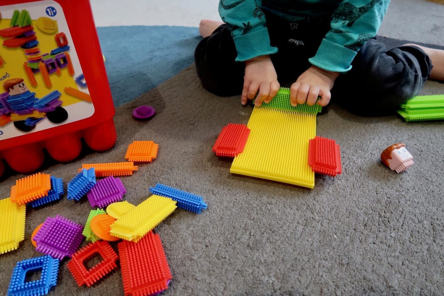 A boy playing with stickle bricks