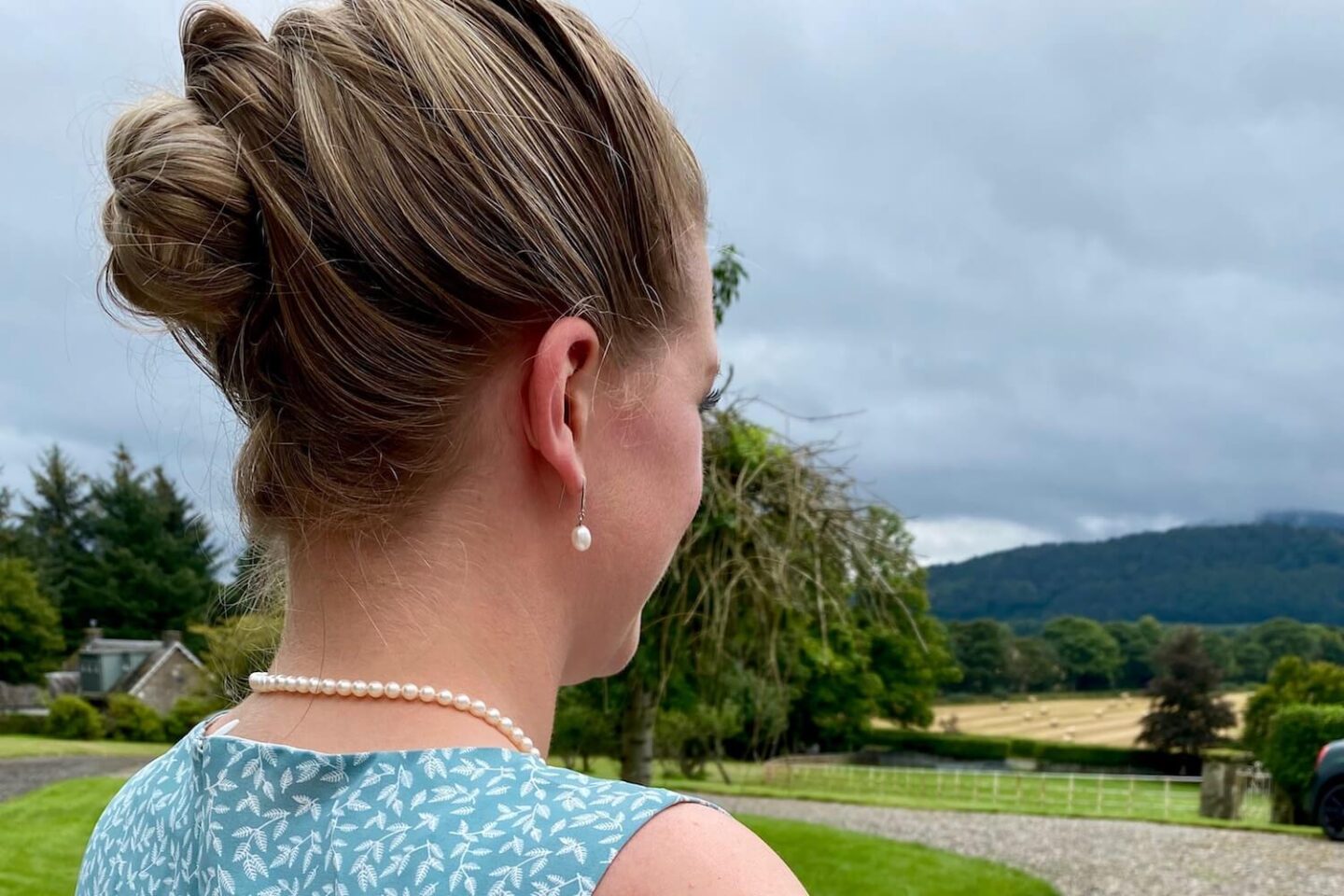 A side view of a woman with her hair in a french plait with a bun
