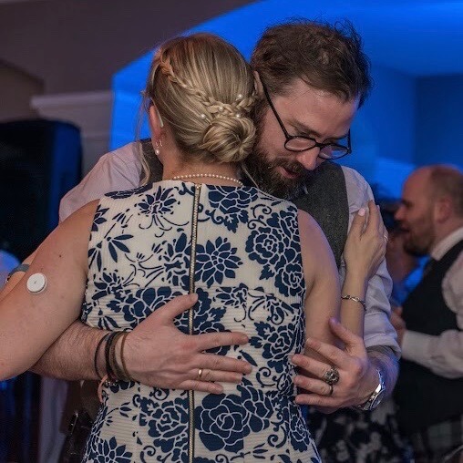 A man and woman hold each other on the dance floor at a wedding
