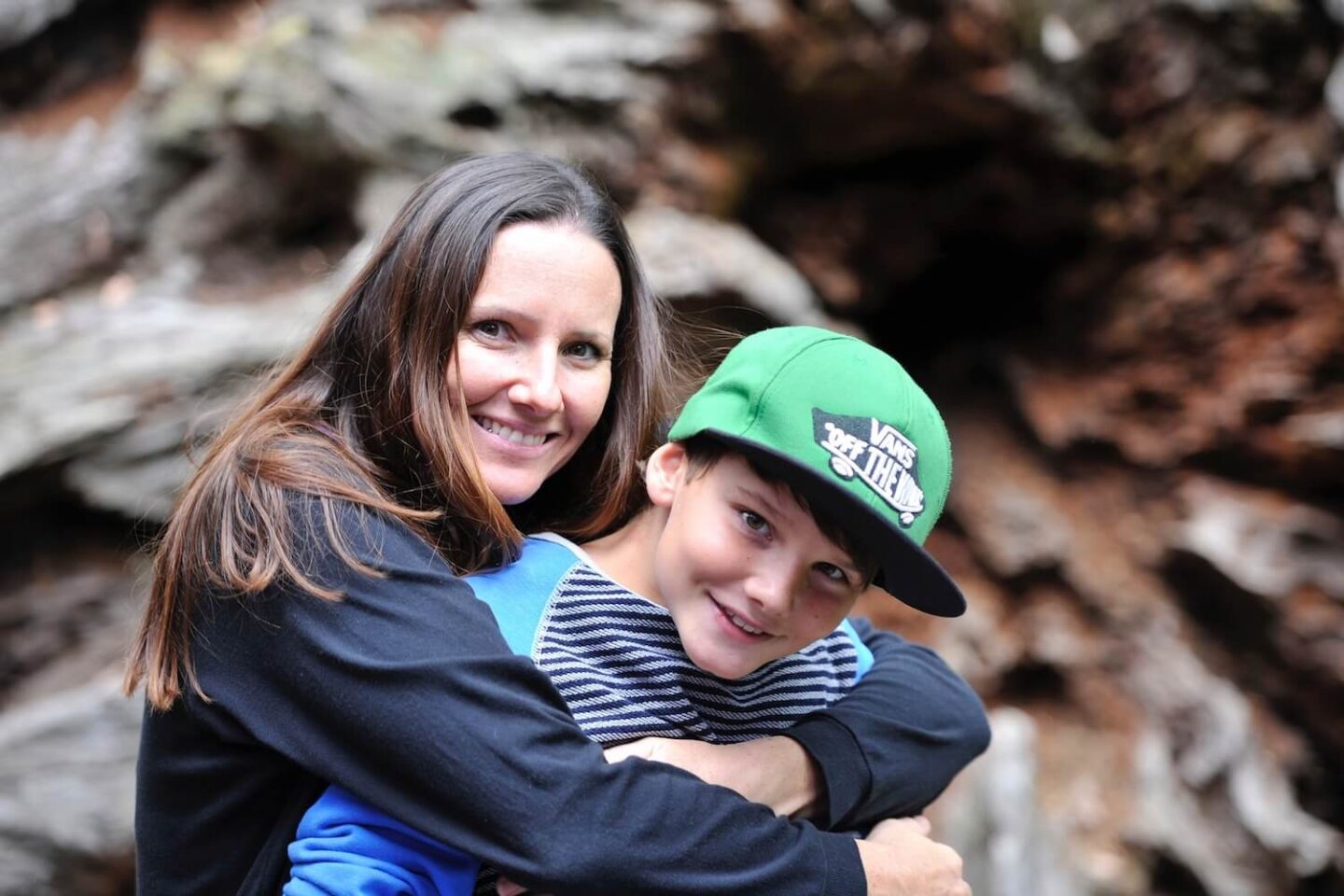 A mother with her arms around her son outside