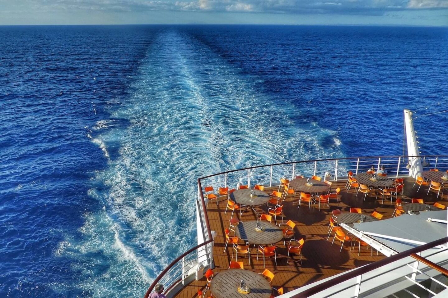 The back end of a cruise ship with the wake in the sea