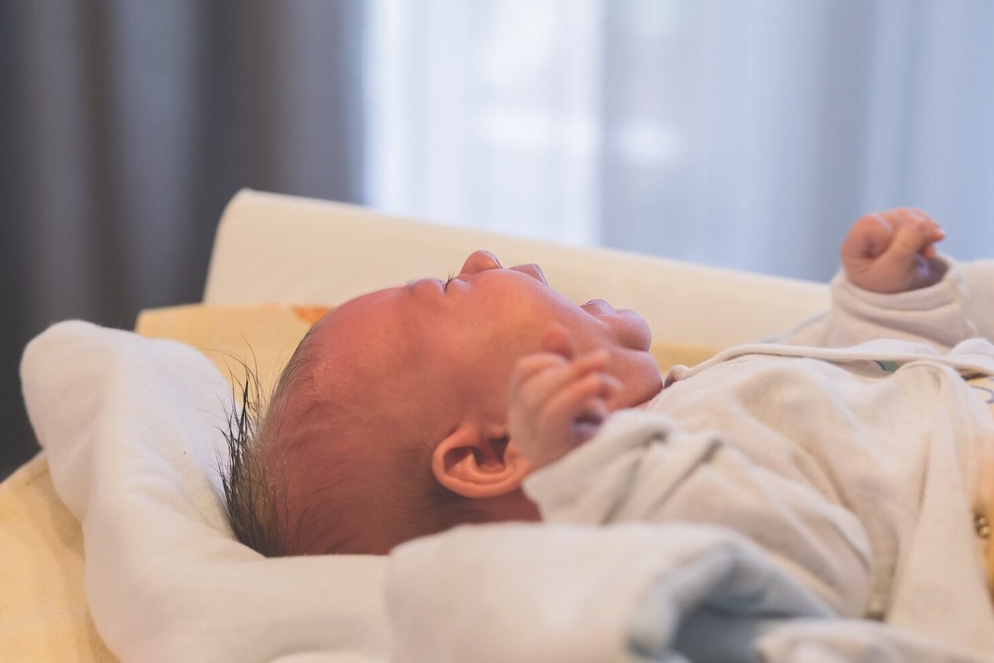 A newborn baby on it's back crying