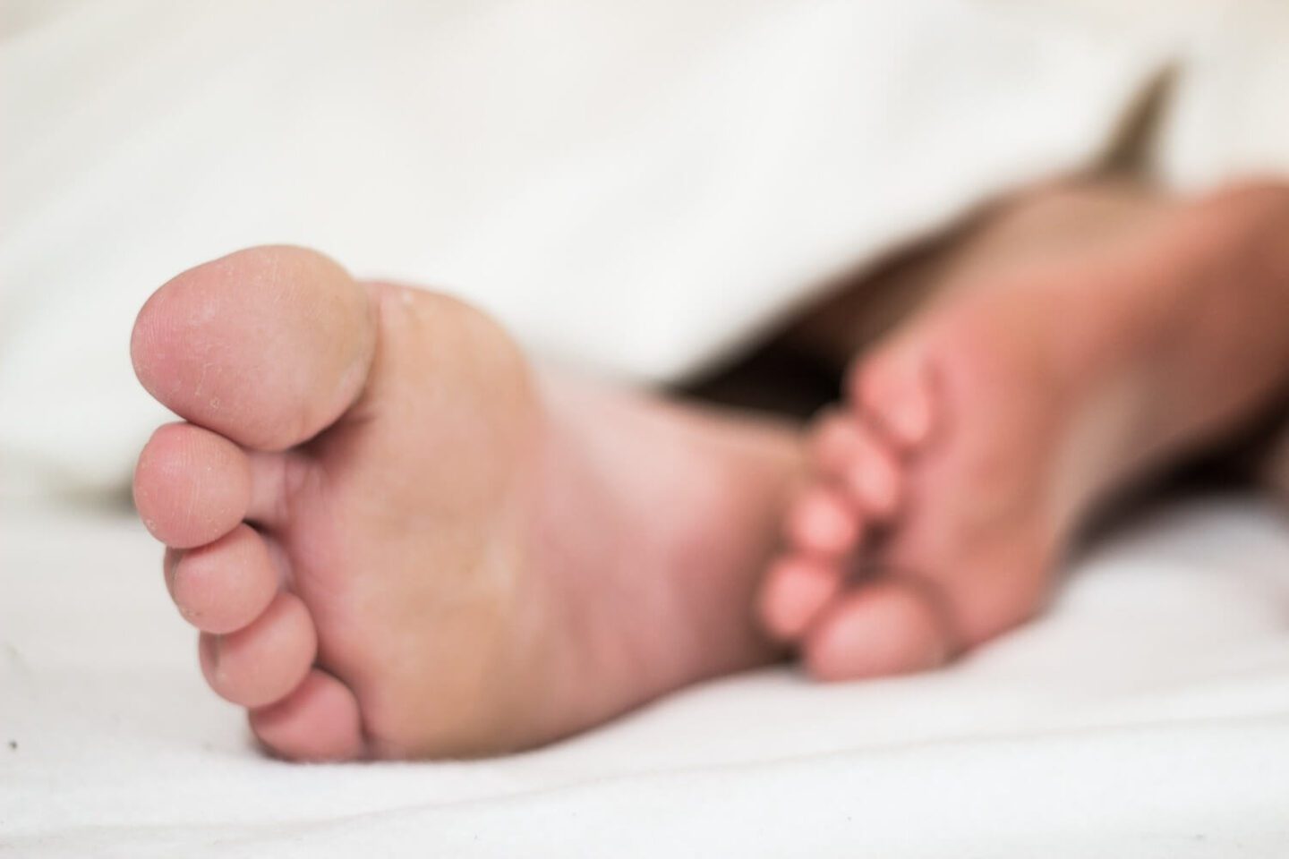 Bare feet sticking out the bottom of a duvet