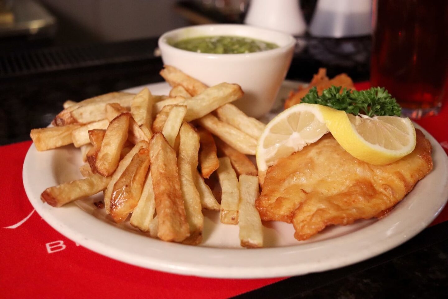 A plate of battered fish, chips and mushy peas