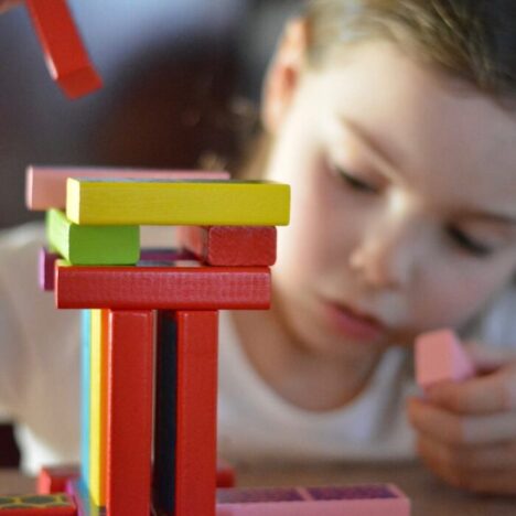 a young girl stacking blocks