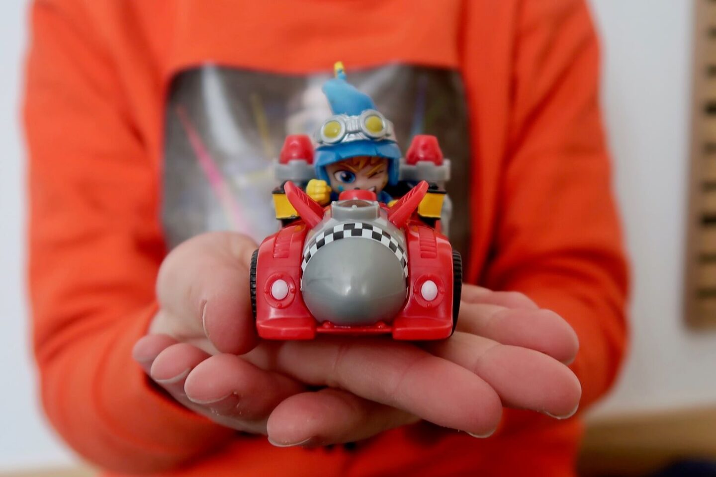 A child's racing car you being held on a child's hand