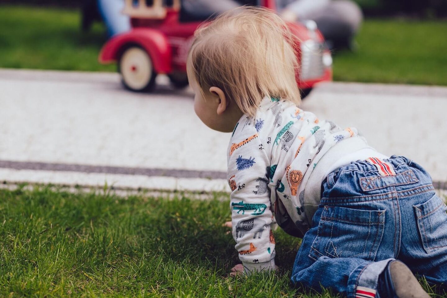 A baby crawling on grass