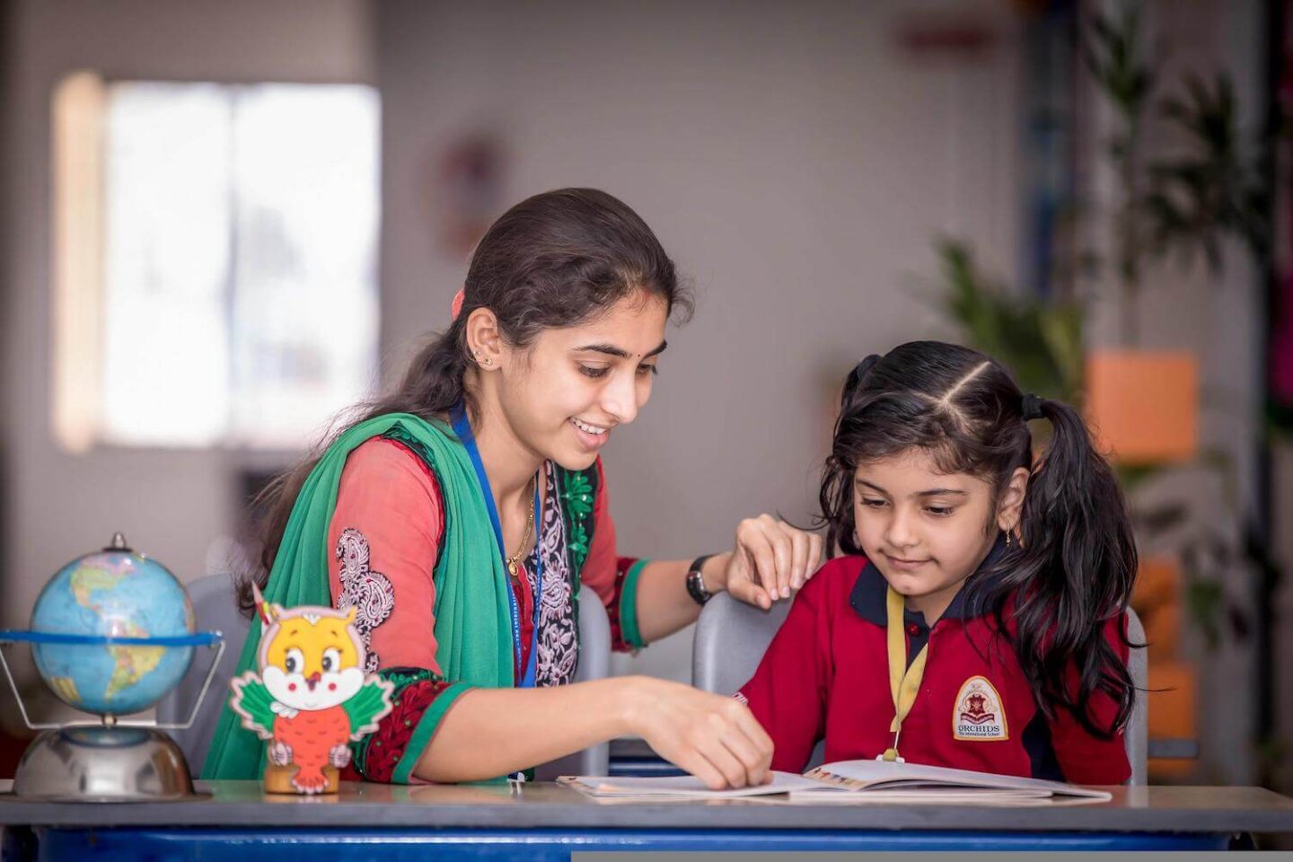 A woman looking at a book with a young girl