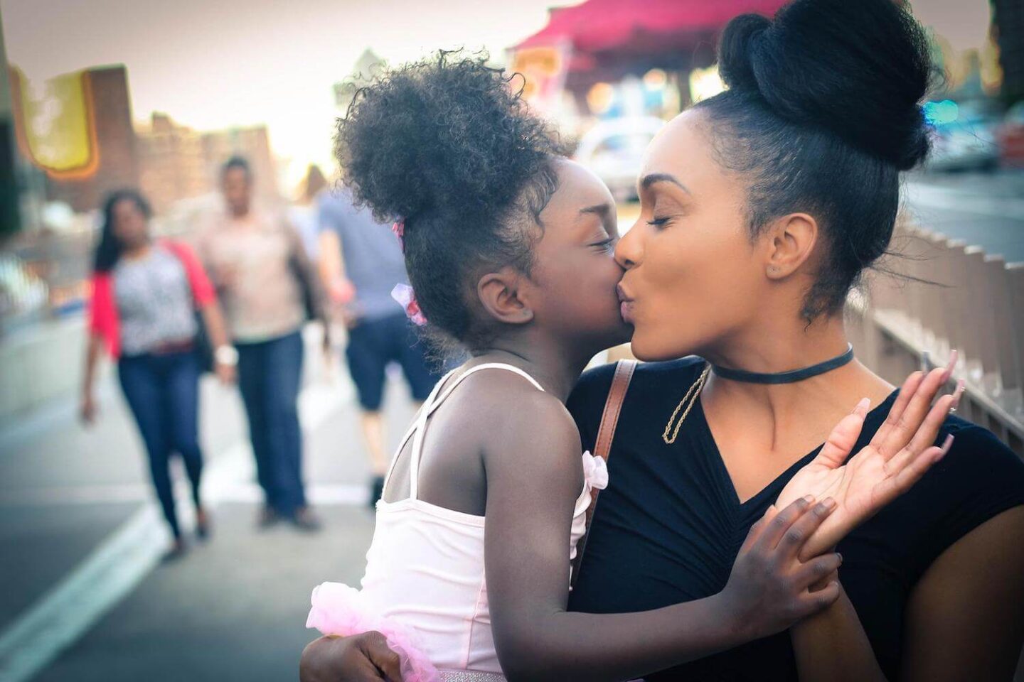 A mother kissing her young daughter