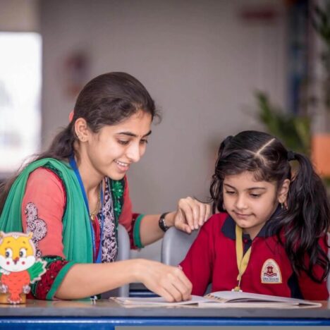 A woman looking at a book with a young girl