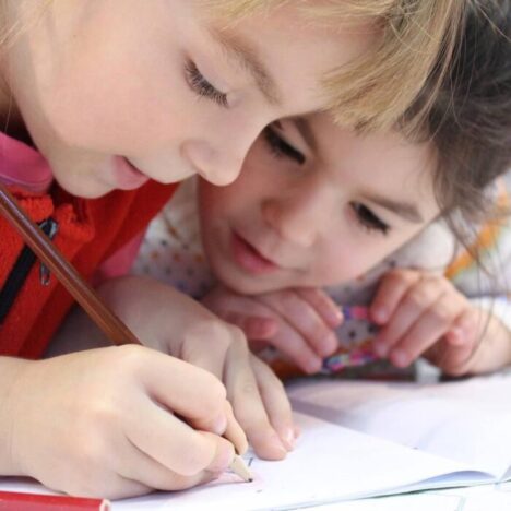2 children bent over a workbook