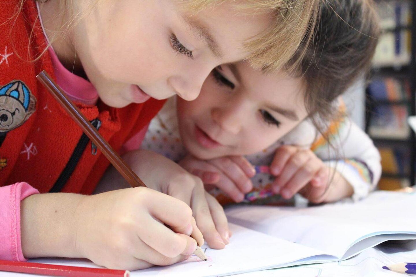 2 children bent over a workbook