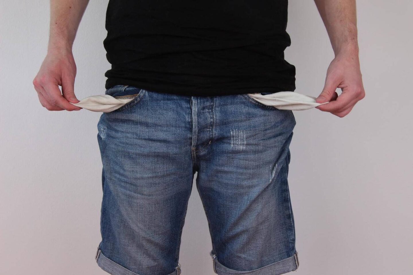 Jeans shorts on a man with the pockets pulled out and empty
