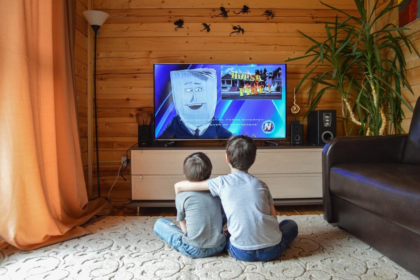 2 boys sitting on the floor watching TV