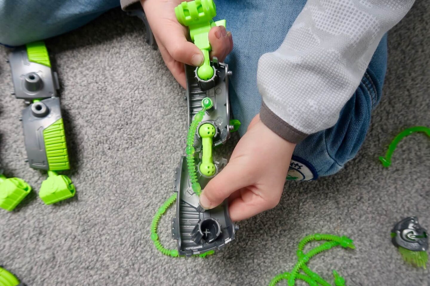 A child's hands putting together the leg of a Gigabot toy