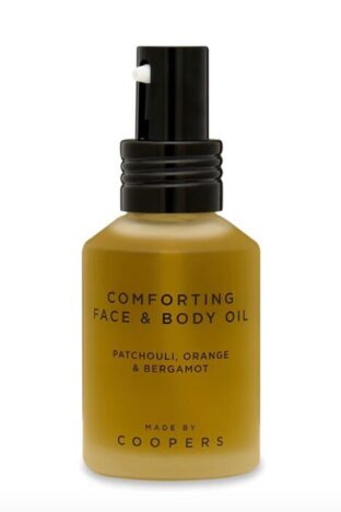 A bottle of face and body oil with a black lid