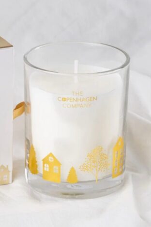 A white candle in a glass jar with gold decoration on it