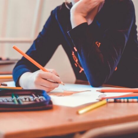 A person sitting at a table and colouring in a picture