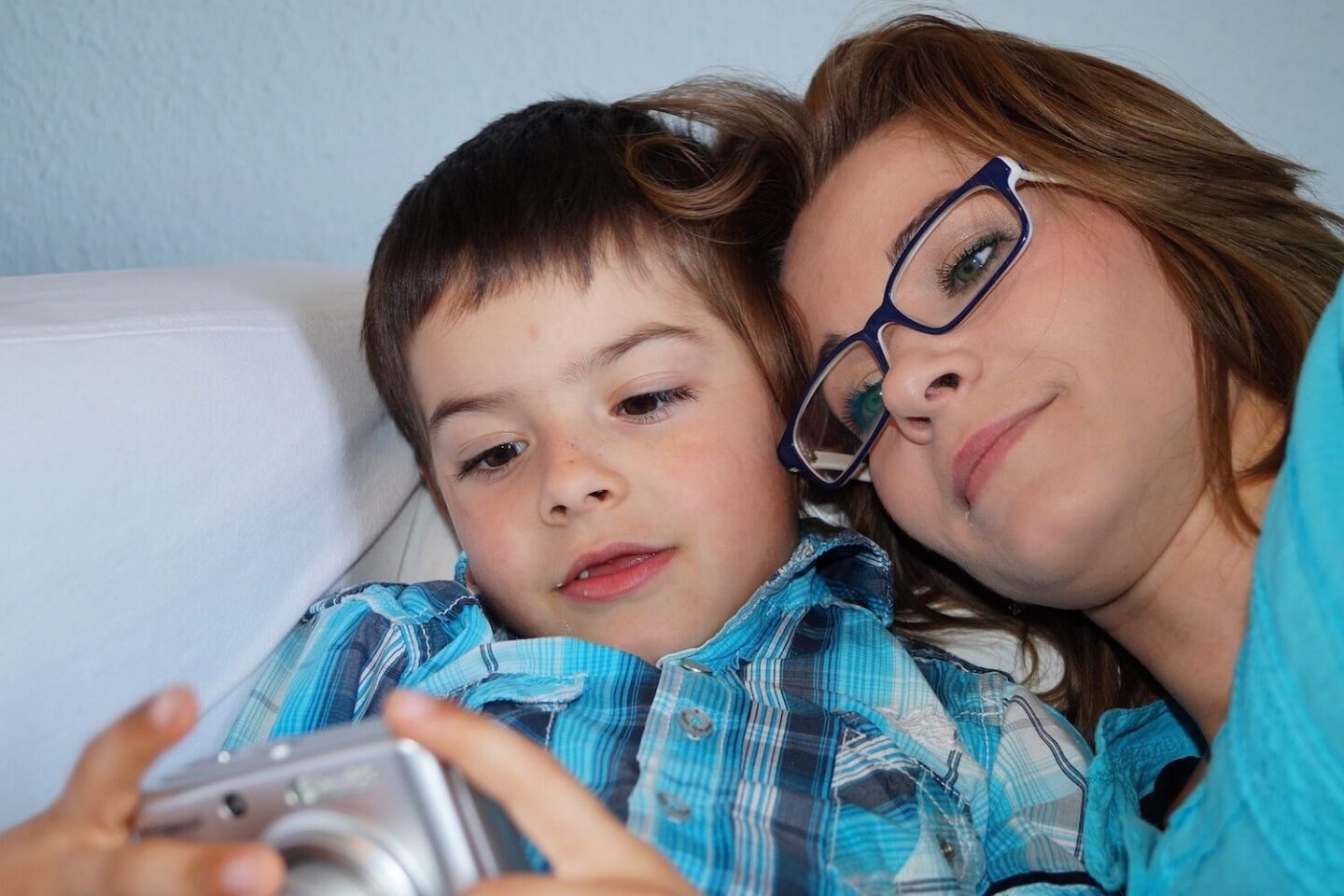 A woman and young boy looking at the screen on a camera