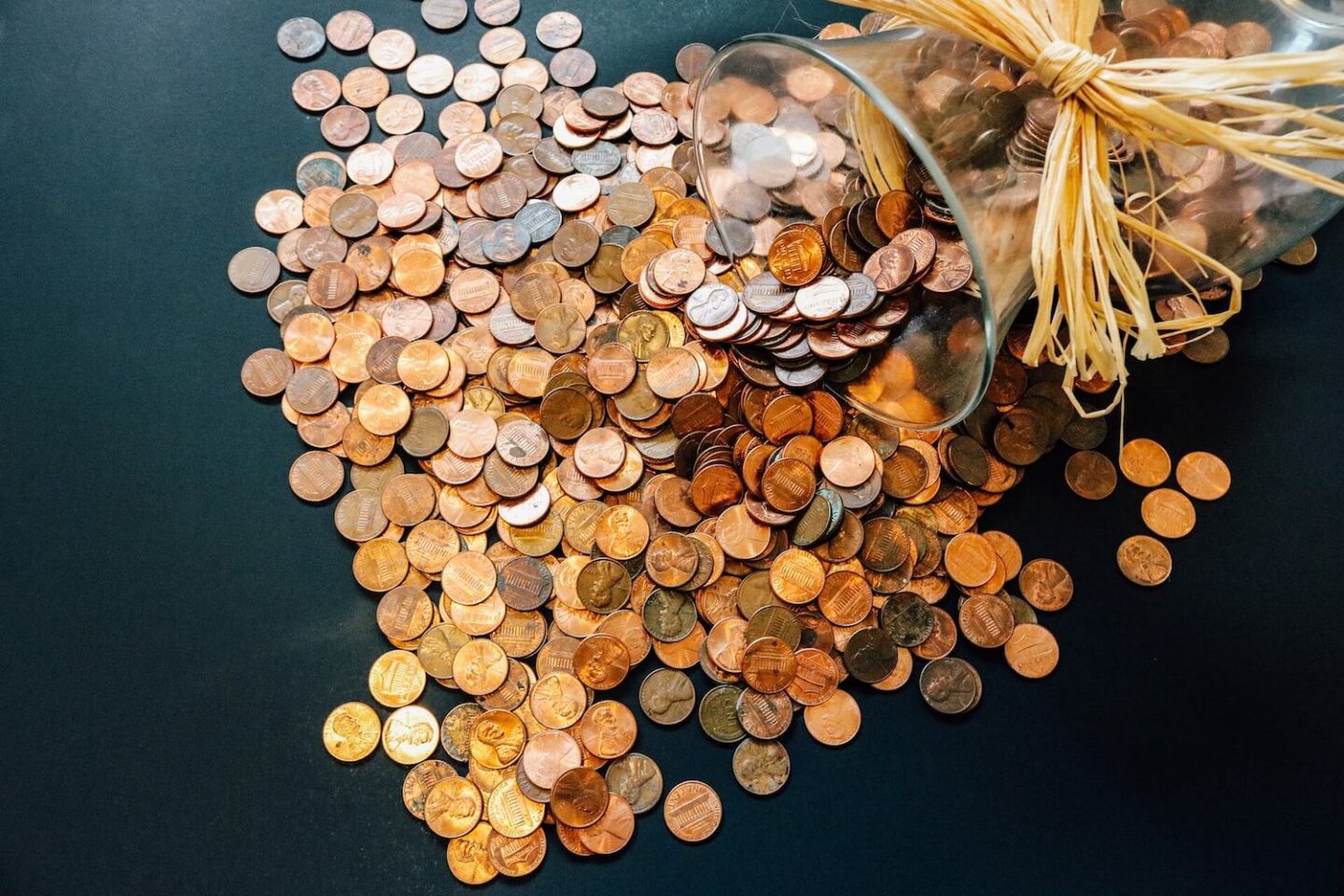 copper coins spilling out of a glass vase
