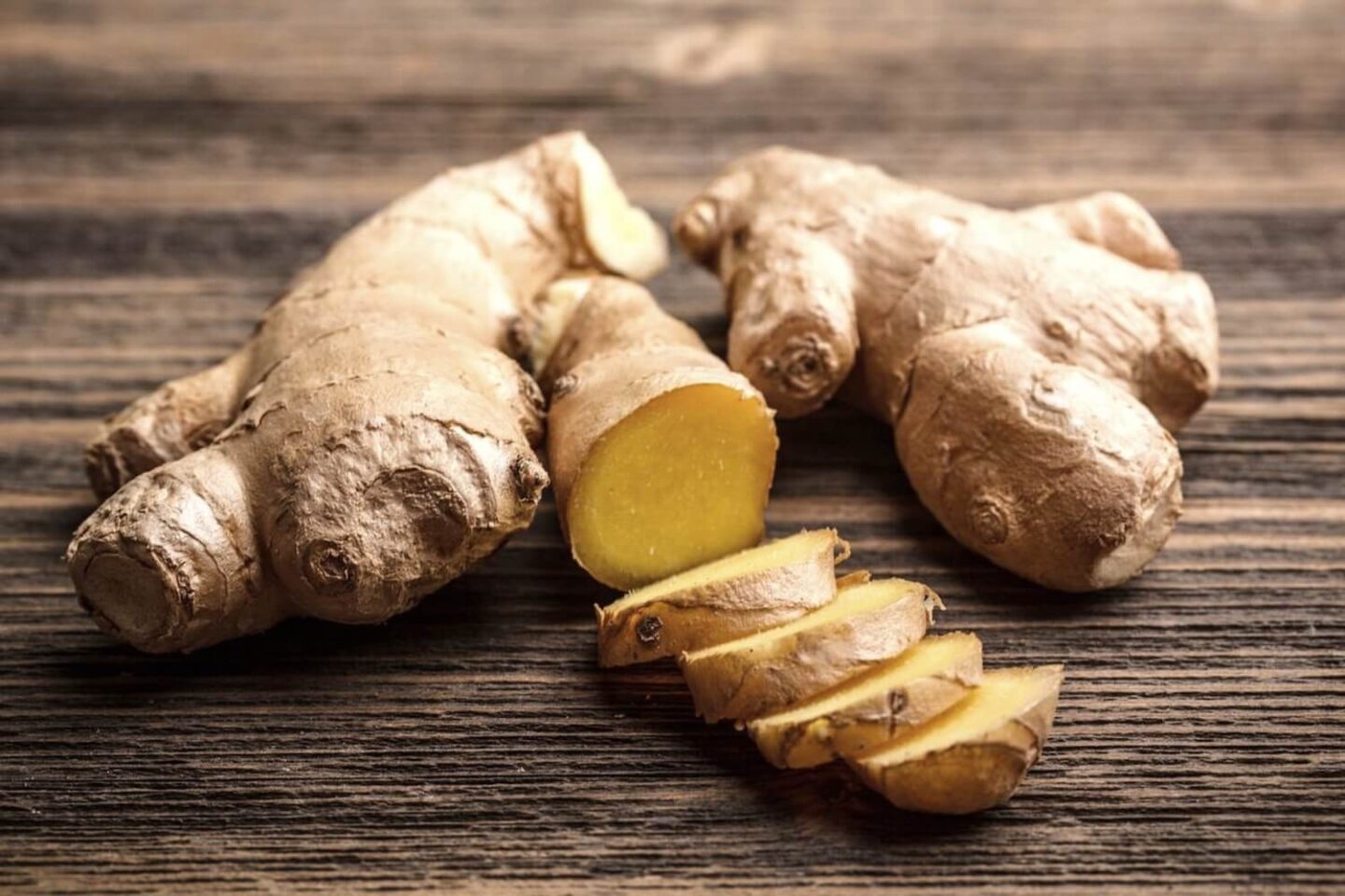 2 pieces of fresh root ginger on a wooden surface