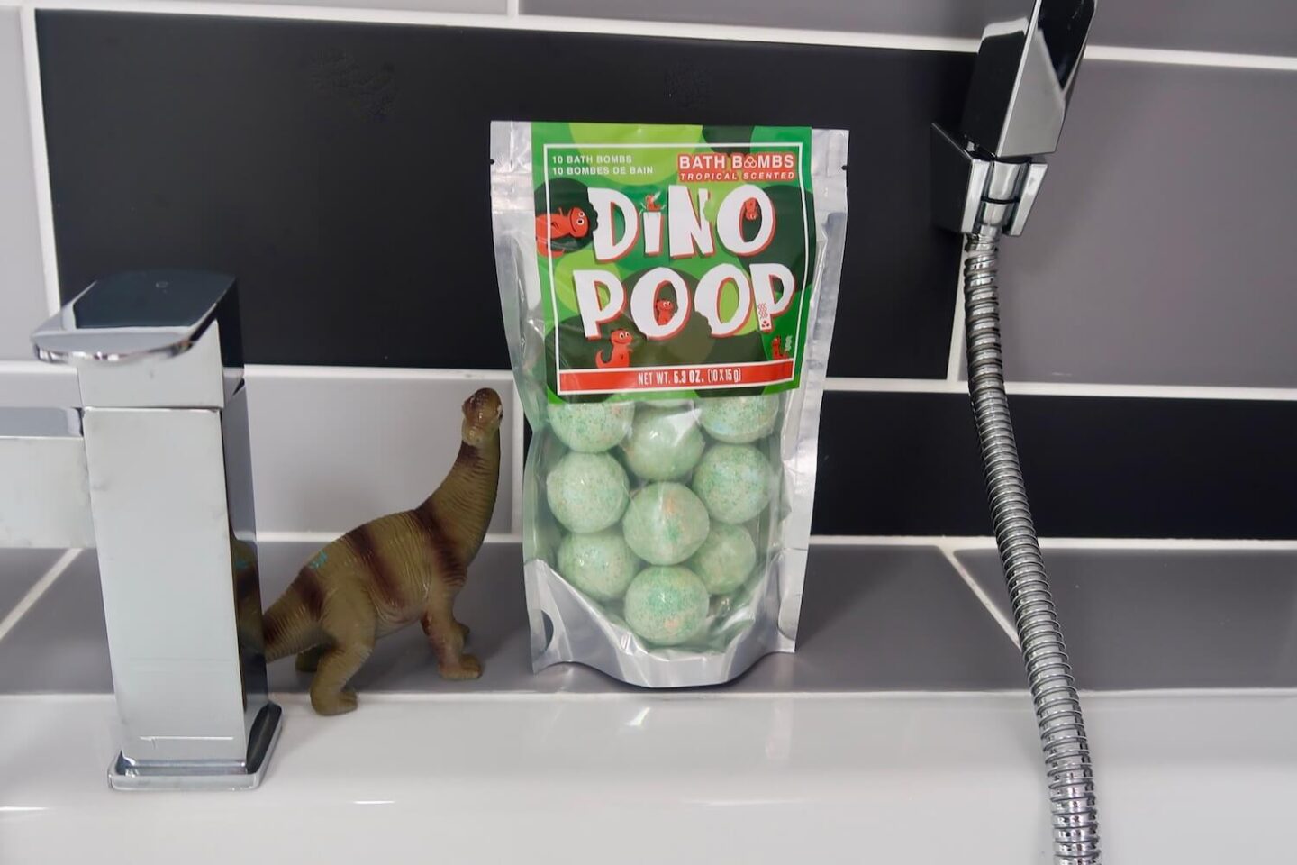 A bag of green balls in a bathroom. Written on it is "Dino Poop"