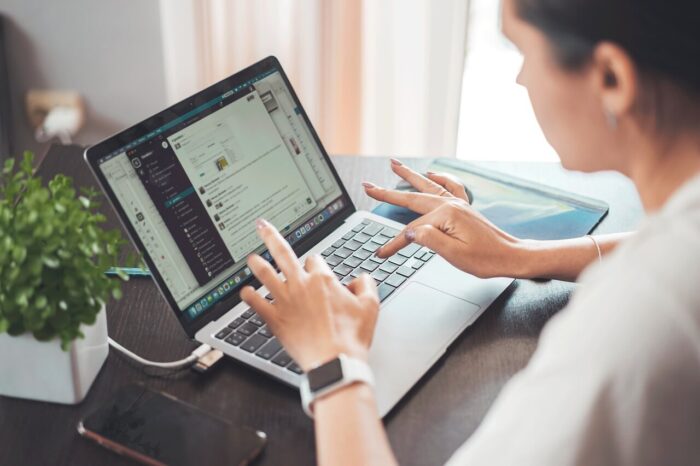 A Mac laptop with a person working on it