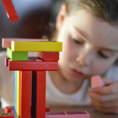 A girl using small blocks to build a tower